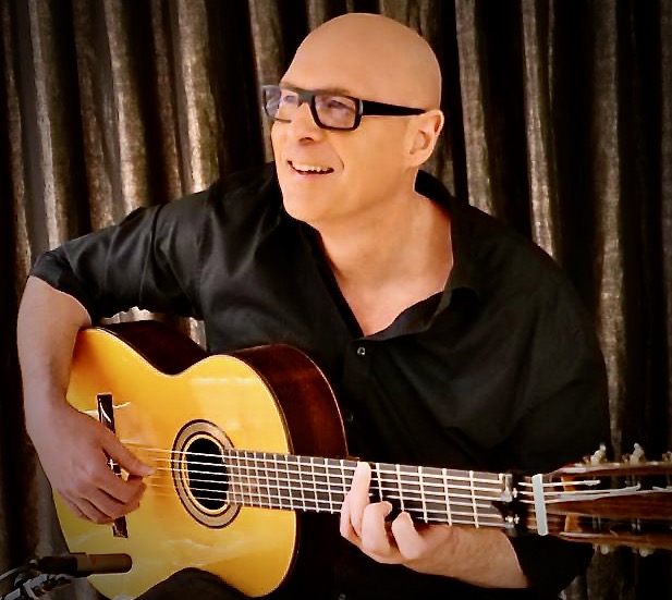 Musiker David Kayy mit Brille und Gitarre